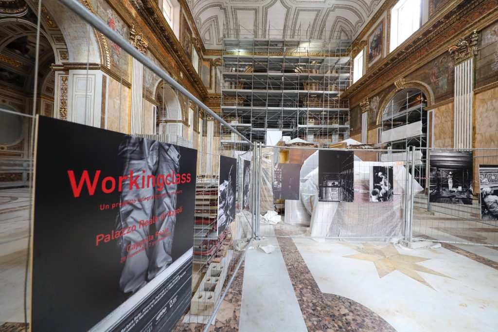 Restauri al Palazzo Reale di Napoli:

dopo 100 giorni torna a splendere lo Scalone d’Onore

WhatsApp Image 2024-11-28 at 13.43.26.jpeg

 “Working Class”, una mostra in 15 foto

che rappresentano il lavoro dei restauratori nella Cappella Reale

Napoli, 28 novembre 2024 - Per un cantiere che si chiude un altro apre a Palazzo Reale.  Si sono appena conclusi in cento giorni i lavori di restauro, pulizia e lucidatura dello Scalone d’Onore e si lavora alla messa in sicurezza della Cappella Reale al quale seguirà un minuzioso restauro.

“Un altro tassello si aggiunge all’immensa mappa di lavori che si svolgono quotidianamente all’interno del Palazzo Reale - dichiara Paola Ricciardi, dirigente delegato dal Direttore generale Musei, prof. Massimo Osanna -  Oggi, nello stesso momento possiamo osservare i risultati di un restauro concluso e  i lavori di un cantiere  aperto  con il quale rendiamo partecipi i visitatori del duro lavoro che viene svolto da restauratori, alle volte molto impegnativo che si trasforma in arte attraverso una piccola mostra fotografica”.

prima 1.png   dopo 1.jpg
Lo Scalone fu definito nel 1729 da Montesquieu “le plus beau escalier d’Europe”, ma quando il celebre filosofo ebbe modo di ammirarlo l’opera era costruita da Francesco Antonio Picchiatti tra il 1651 e il 1666 in pietra di piperno. In realtà quello che vediamo oggi fu progettato ex novo in marmo da Gaetano Genovese nel restauro generale dell’edificio risalente agli anni Quaranta del XIX secolo e rappresenta il simbolo del Palazzo Reale di Napoli.

Il tempo, gli incendi e gli agenti atmosferici avevano creato una serie di macchie che, grazie al lavoro di conservazione affidato al Consorzio CO.MA.BER, eseguito dalla ditta Officine Marmi Italia specializzata nel campo dei marmi e del restauro   e con la  direzione dei lavori affidata all’arch. Stefano Gei, sono state attenuate restituendo al marmo di Carrara la sua originale luminosità.

prima-2.jpg  dopo2.jpg

Dopo un’approfondita fase di ricerca sono stati identificati i prodotti più idonei per trattare la superficie degli scalini. Dopo aver effettuato una pulitura per rimuovere lo sporco e le impurità sono stati applicati sulle macchie più evidenti e a più riprese impacchi per 24 ore al fine di estrarre le ossidazioni. L’ultimo intervento è stato quello della lucidatura con l’applicazione di un protettivo per preservare le superfici e migliorare la resistenza all’umidità. Il cantiere è stato aperto il 16 giugno scorso e oggi, dopo cento giorni effettivi di lavoro, è stata restituita ai visitatori una visione luminosa e brillante dell’opera architettonica della reggia napoletana.

L’immenso Scalone ha un’estensione 750 mq di per un’altezza di 30 metri circa e conduce all’Appartamento Storico al piano nobile dove si trova anche la Cappella Reale nella quale stanno per concludersi i lavori di Somma Urgenza che ha riguardato le superfici decorate della Cappella Reale, danneggiate da infiltrazioni d’acqua nel corso degli anni.

Il coordinamento alla sicurezza di entrambi i lavori è stato affidato all'arch. Maria Vittoria Iazzetti.

Almerinda Padricelli, funzionario architetto di Palazzo Reale  e responsabile del progetto ricorda che “I due interventi sono finanziati dal Grande Progetto del MIC. Il primo restituisce la visione luminosa e candida dei marmi dello Scalone, mentre nel secondo intervento i lavori sono stati eseguiti per consolidare e mappare superfici preziose, ma hanno anche consentito di effettuare degli studi approfonditi e importanti per orientare la progettazione del futuro cantiere di completamento del restauro delle superfici, in modo da valorizzare al meglio le aree di intervento nella Cappella Reale”.

La messa in sicurezza effettuata con carattere di somma urgenza per cui sono stati impegnati 400mila euro precede, infatti, il restauro delle parti ammalorate della Cappella, che ha un capitolo di spesa di un milione di euro.

Prima dell’inizio del restauro vero e proprio si è pensato di allestire una piccola mostra fotografica "Working Class", un progetto fotografico nato da un’idea di Barbara Balbi, restauratrice ABAP, Almerinda Padricelli, responsabile del progetto e la  collaborazione dei restauratori e delle restauratrici di Tecnicon srl  coordinati da  Luigia Gambino e di Francesca Di Martino restauratrice di Palazzo Reale.

il team dei restaurti.jpg

Nelle 15 fotografie di Camillo Ripaldi, esposte su sei pannelli nel cantiere ancora attivo, sono rappresentati momenti di lavoro di alcuni dei 20, restauratrici e restauratori nei due mesi di lavoro svolto.

"La mostra sottolinea alcuni aspetti meno consueti del lavoro dei restauratori mettendo in evidenza quanto il restauro sia gravoso dal punto di vista fisico e al contempo stabilisca un legame strettissimo con la materia dell'opera d'arte. - racconta Barbara Balbi, direttrice dei lavori - L'occasione di un cantiere di grandi dimensioni, inoltre, fa riflettere sulla sicurezza dei lavoratori in un momento storico in cui il tema è ancora molto sentito: in questo senso la fotografia aiuta a guardare meglio e da più vicino".

cappella.jpg    PHOTO-2024-11-28-14-12-59.jpg
 La mostra, gratuita per i visitatori di Palazzo Reale, sarà aperta dal 28 novembre 2024 al 7 gennaio 2025.