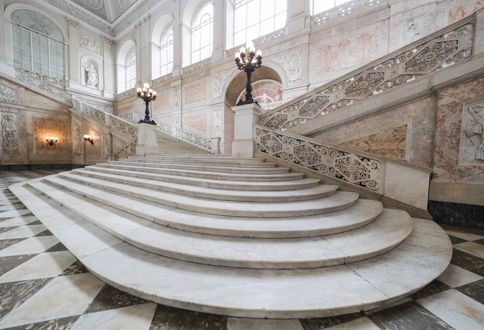 Restauri al Palazzo Reale di Napoli: dopo 100 giorni torna a splendere lo Scalone d’Onore WhatsApp Image 2024-11-28 at 13.43.26.jpeg “Working Class”, una mostra in 15 foto che rappresentano il lavoro dei restauratori nella Cappella Reale Napoli, 28 novembre 2024 - Per un cantiere che si chiude un altro apre a Palazzo Reale. Si sono appena conclusi in cento giorni i lavori di restauro, pulizia e lucidatura dello Scalone d’Onore e si lavora alla messa in sicurezza della Cappella Reale al quale seguirà un minuzioso restauro. “Un altro tassello si aggiunge all’immensa mappa di lavori che si svolgono quotidianamente all’interno del Palazzo Reale - dichiara Paola Ricciardi, dirigente delegato dal Direttore generale Musei, prof. Massimo Osanna - Oggi, nello stesso momento possiamo osservare i risultati di un restauro concluso e i lavori di un cantiere aperto con il quale rendiamo partecipi i visitatori del duro lavoro che viene svolto da restauratori, alle volte molto impegnativo che si trasforma in arte attraverso una piccola mostra fotografica”. prima 1.png dopo 1.jpg Lo Scalone fu definito nel 1729 da Montesquieu “le plus beau escalier d’Europe”, ma quando il celebre filosofo ebbe modo di ammirarlo l’opera era costruita da Francesco Antonio Picchiatti tra il 1651 e il 1666 in pietra di piperno. In realtà quello che vediamo oggi fu progettato ex novo in marmo da Gaetano Genovese nel restauro generale dell’edificio risalente agli anni Quaranta del XIX secolo e rappresenta il simbolo del Palazzo Reale di Napoli. Il tempo, gli incendi e gli agenti atmosferici avevano creato una serie di macchie che, grazie al lavoro di conservazione affidato al Consorzio CO.MA.BER, eseguito dalla ditta Officine Marmi Italia specializzata nel campo dei marmi e del restauro e con la direzione dei lavori affidata all’arch. Stefano Gei, sono state attenuate restituendo al marmo di Carrara la sua originale luminosità. prima-2.jpg dopo2.jpg Dopo un’approfondita fase di ricerca sono stati identificati i prodotti più idonei per trattare la superficie degli scalini. Dopo aver effettuato una pulitura per rimuovere lo sporco e le impurità sono stati applicati sulle macchie più evidenti e a più riprese impacchi per 24 ore al fine di estrarre le ossidazioni. L’ultimo intervento è stato quello della lucidatura con l’applicazione di un protettivo per preservare le superfici e migliorare la resistenza all’umidità. Il cantiere è stato aperto il 16 giugno scorso e oggi, dopo cento giorni effettivi di lavoro, è stata restituita ai visitatori una visione luminosa e brillante dell’opera architettonica della reggia napoletana. L’immenso Scalone ha un’estensione 750 mq di per un’altezza di 30 metri circa e conduce all’Appartamento Storico al piano nobile dove si trova anche la Cappella Reale nella quale stanno per concludersi i lavori di Somma Urgenza che ha riguardato le superfici decorate della Cappella Reale, danneggiate da infiltrazioni d’acqua nel corso degli anni. Il coordinamento alla sicurezza di entrambi i lavori è stato affidato all'arch. Maria Vittoria Iazzetti. Almerinda Padricelli, funzionario architetto di Palazzo Reale e responsabile del progetto ricorda che “I due interventi sono finanziati dal Grande Progetto del MIC. Il primo restituisce la visione luminosa e candida dei marmi dello Scalone, mentre nel secondo intervento i lavori sono stati eseguiti per consolidare e mappare superfici preziose, ma hanno anche consentito di effettuare degli studi approfonditi e importanti per orientare la progettazione del futuro cantiere di completamento del restauro delle superfici, in modo da valorizzare al meglio le aree di intervento nella Cappella Reale”. La messa in sicurezza effettuata con carattere di somma urgenza per cui sono stati impegnati 400mila euro precede, infatti, il restauro delle parti ammalorate della Cappella, che ha un capitolo di spesa di un milione di euro. Prima dell’inizio del restauro vero e proprio si è pensato di allestire una piccola mostra fotografica 